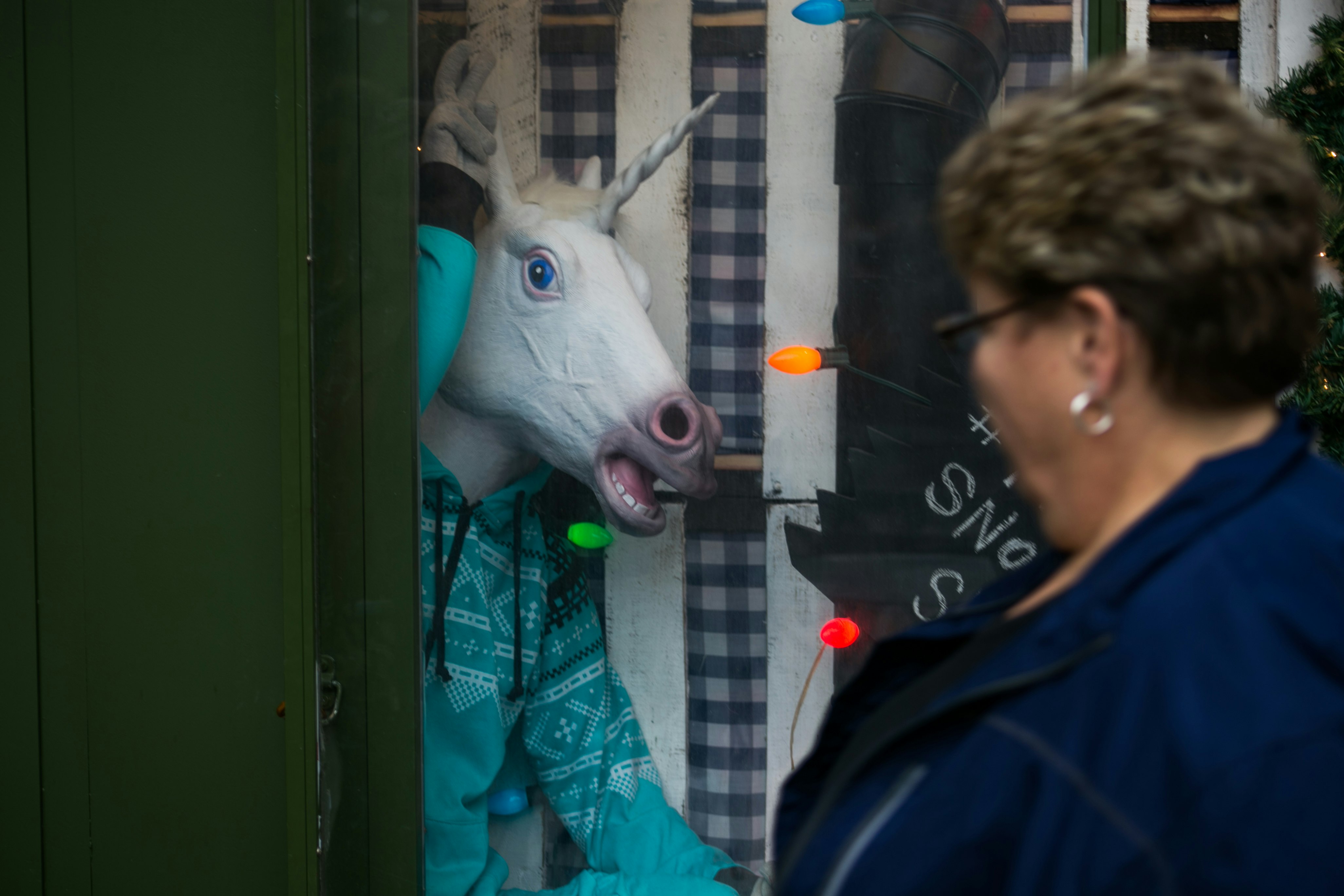 woman standing in front of white unicorn statue